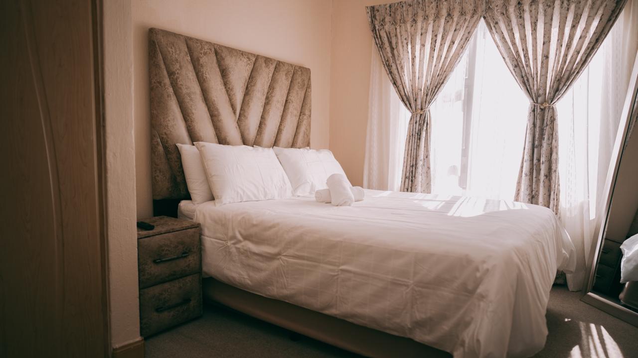 Le Voila bedroom with padded headboard and bright window